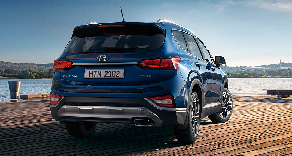 Rear view of blue Santa Fe with mountain background